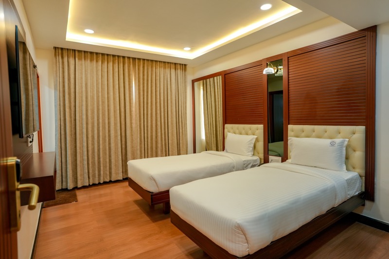 Twin room with two single beds and full-height curtains